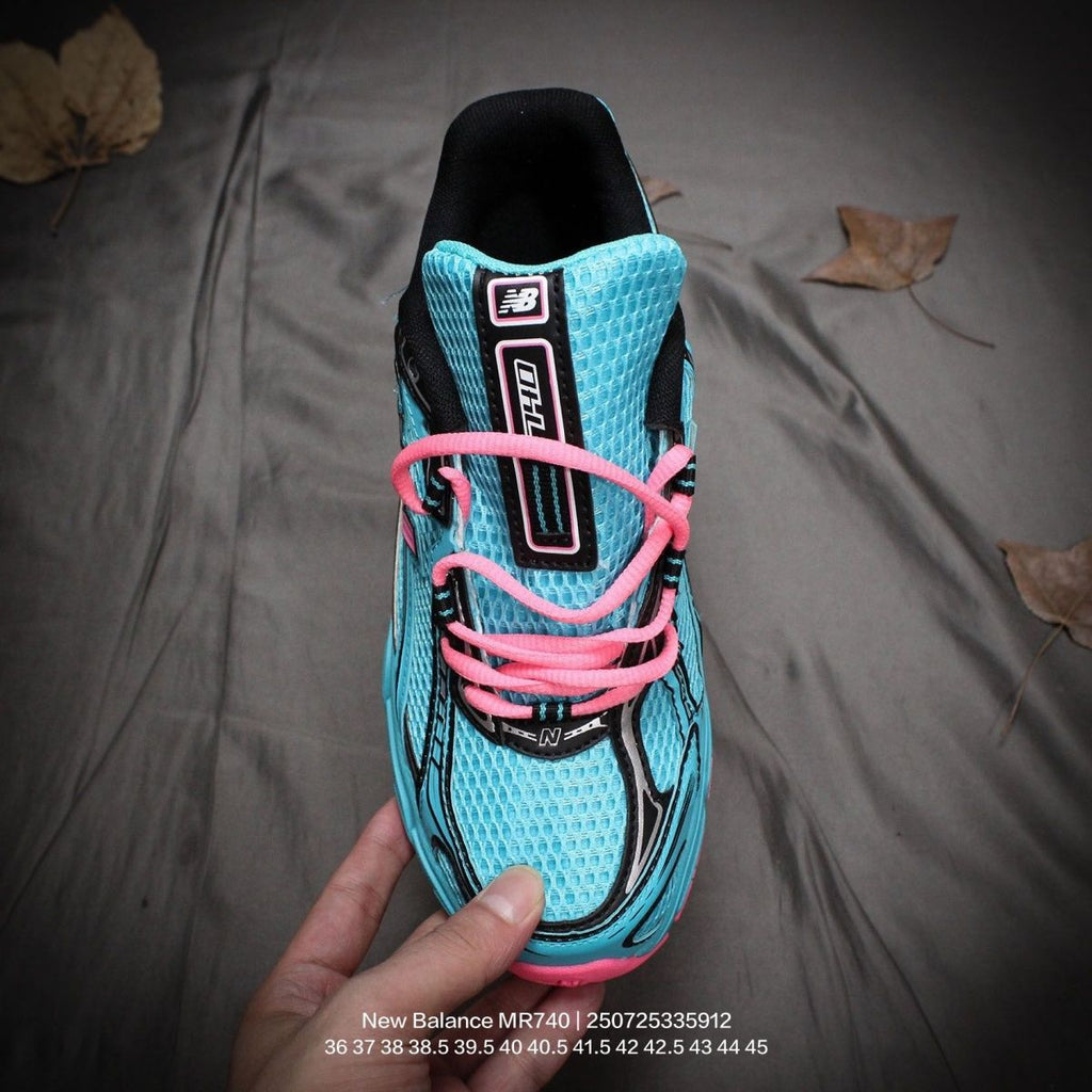 The New Balance 740v2 Cyber Jade features a breathable mesh upper with vibrant blue and neon pink accents, inspired by 2000s running style