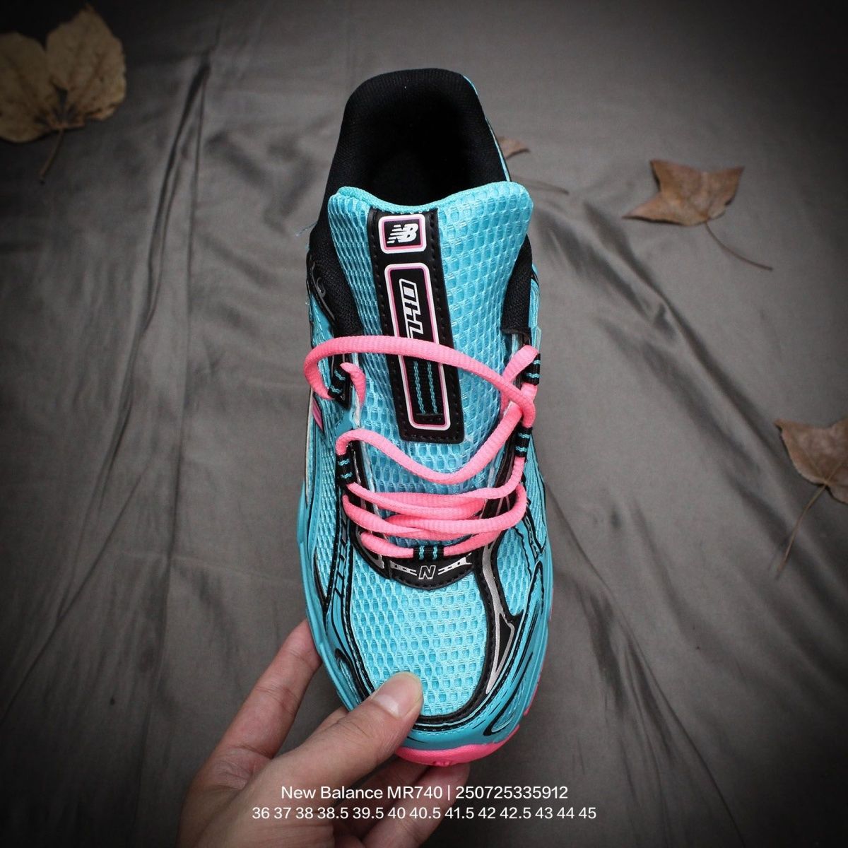 The New Balance 740v2 Cyber Jade features a breathable mesh upper with vibrant blue and neon pink accents, inspired by 2000s running style